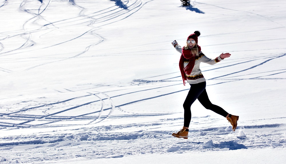 Running woman runner in winter mountains on snow